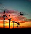 Windräder im Sonnenuntergang mit Hubschrauber