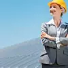 Woman investor in clean energy standing in front of solar panels