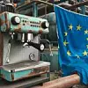 Verrostete Maschine und daneben eine Europa-Flagge