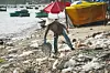 Vietnamese woman throws garbage on the beach by the sea. Dump by the sea. bad ecology in Southeast Asia. Fishermen village in MUI ne