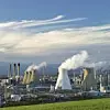 rauchendes Kraftwerk an großem Industriestandort mit blauem Himmel