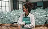 Bottling plant Young happy female worker in bottling factory recycling department. Inspection quality control. junge weibliche Mitarbeiterin mit leeren Plastik Flaschen im Hintergrund