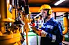 Heating plant technician standing by gas pipes and maintaining t