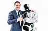 Mann im Anzug umarmt einen Roboter und macht Daumen hoch