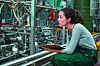 Female factory worker maintaining record on clipboard in factory