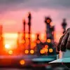 Worker Hand Holding Safety Helmet At Sunset Oil Refinery