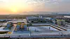 Weitwinkelansicht eines Industrieareals bei Sonnenaufgang mit mehreren Gebäuden und Anlagen.