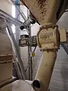 Industrierohre und Motor einer Anlage zur Kalkverarbeitung in Fabrikumgebung.