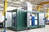 Grüner Technik-Container mit geöffneter Seite in einer Industriehalle