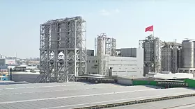 Großer Industriekomplex mit Hochsilos und Fabrikgebäuden unter blauem Himmel
