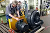 Techniker arbeitet an großem Industriegebläse in einer Werkhalle