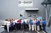 Personengruppe schneidet blaues Band vor BASF-Gebäude mit Logo durch.
