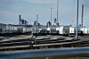 Silberne Tankwaggons auf Gleisen in einem Industrie- und Rangierbahnhof.
