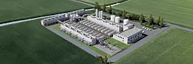 Luftbild einer Industrieanlage mit Gebäuden, Tanks und Straßen neben grünen Feldern.