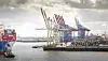 Containerhafen mit Frachtschiff, Hafenkränen und gestapelten Containern in der Region Rotterdam.