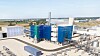 Moderne Industrieanlage mit blauen Türmen, Rohrleitungen und technischen Anlagen auf einem Werksgelände.