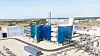 Moderne Industrieanlage mit blauen Türmen, Rohrleitungen und technischen Anlagen auf einem Werksgelände.