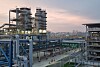 Evonik Fuhua H2O2 Werk in Leshan, China; Große Industrieanlage mit Stahlrohren und Türmen bei Sonnenuntergang.