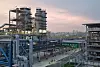 Evonik Fuhua H2O2 Werk in Leshan, China; Große Industrieanlage mit Stahlrohren und Türmen bei Sonnenuntergang.