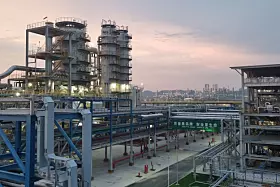 Evonik Fuhua H2O2 Werk in Leshan, China; Große Industrieanlage mit Stahlrohren und Türmen bei Sonnenuntergang.