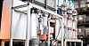 Metallrohre, Ventile und industrielle Behälter in einer technischen Anlage.