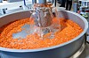 Kunststoffgranulat wird in einem großen Edelstahlbehälter mit Wasser gespült.