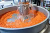 Kunststoffgranulat wird in einem großen Edelstahlbehälter mit Wasser gespült.