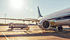 Verkehrsflugzeug am Flughafen mit Bodenfahrzeug und Ausrüstung auf dem Vorfeld.