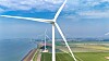 Windräder an einer Küste neben Wasser, Deich und grünen Feldern; Der Onshore-Windpark Karolinapolder am Volkerak bei Dinteloord stellt Strom aus erneuerbarer Quelle für die Wasserstoffproduktion von Air Products bereit.
