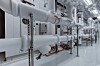 Weiße Rohrleitungen und Armaturen in einem hellen Industrie- und Technikraum.