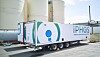 Iphos-Transportauflieger vor großen weißen Industrie-Tanks auf einem Werksgelände.