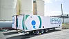 Iphos-Transportauflieger vor großen weißen Industrie-Tanks auf einem Werksgelände.