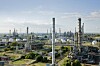 Große Industrieanlage mit Rohren, Türmen und Tanks bei klarem Himmel.