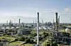 Große Industrieanlage mit Rohren, Türmen und Tanks bei klarem Himmel.