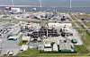 Luftbild eines Industriekomplexes an der Küste mit Gebäuden, Straßen und Dampf.