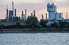 Industrielle BASF-Anlage am Flussufer mit hohem Prillturm und mehreren Schornsteinen im Hintergrund.